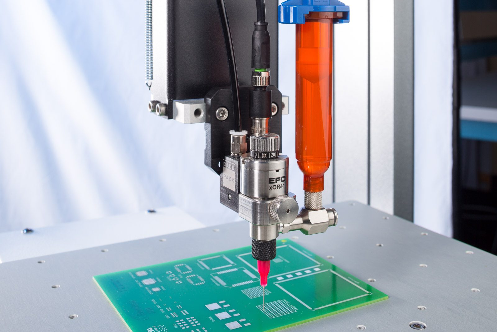 Nordson EFD xQR41 valve with backpack and orange syringe dispensing